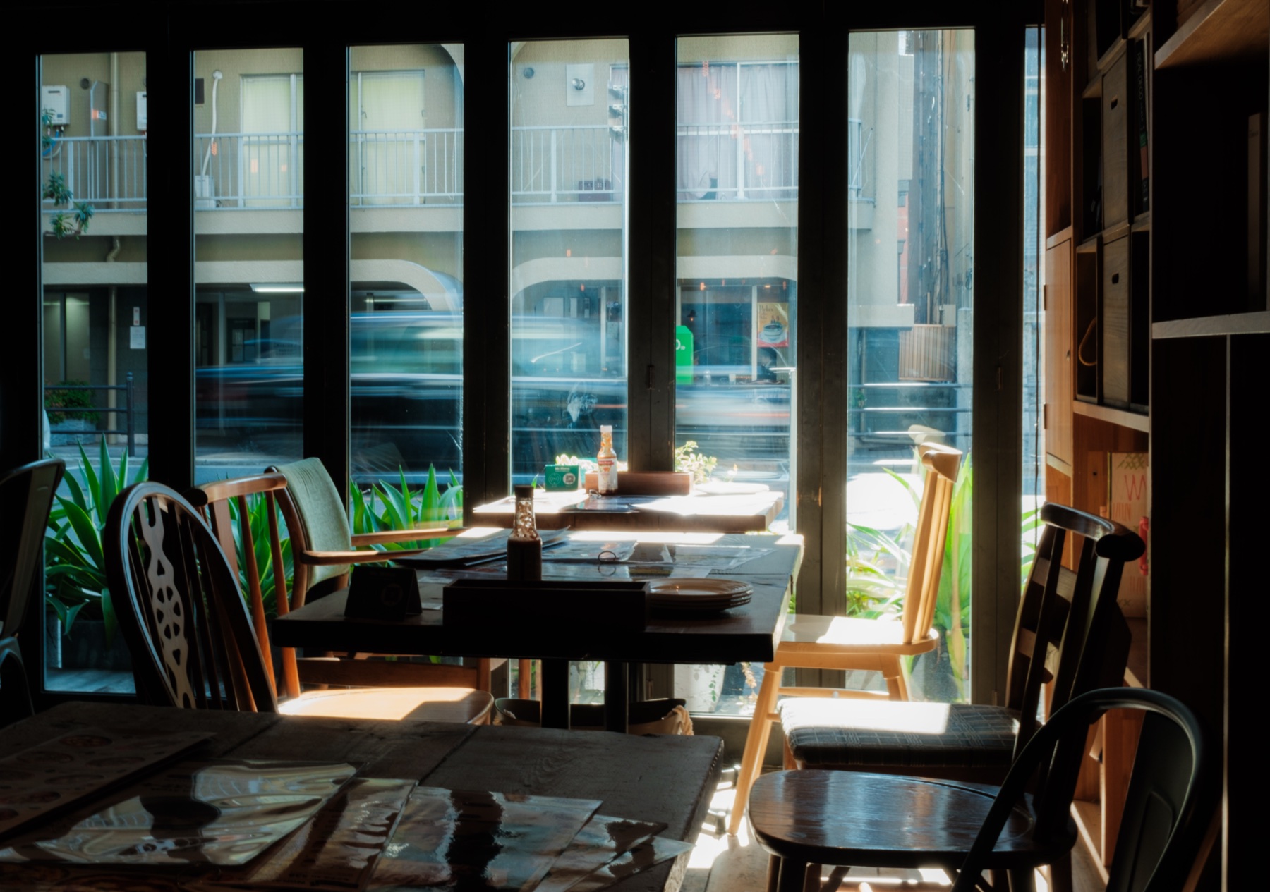 A warm café interior, traffic blurring past the window
