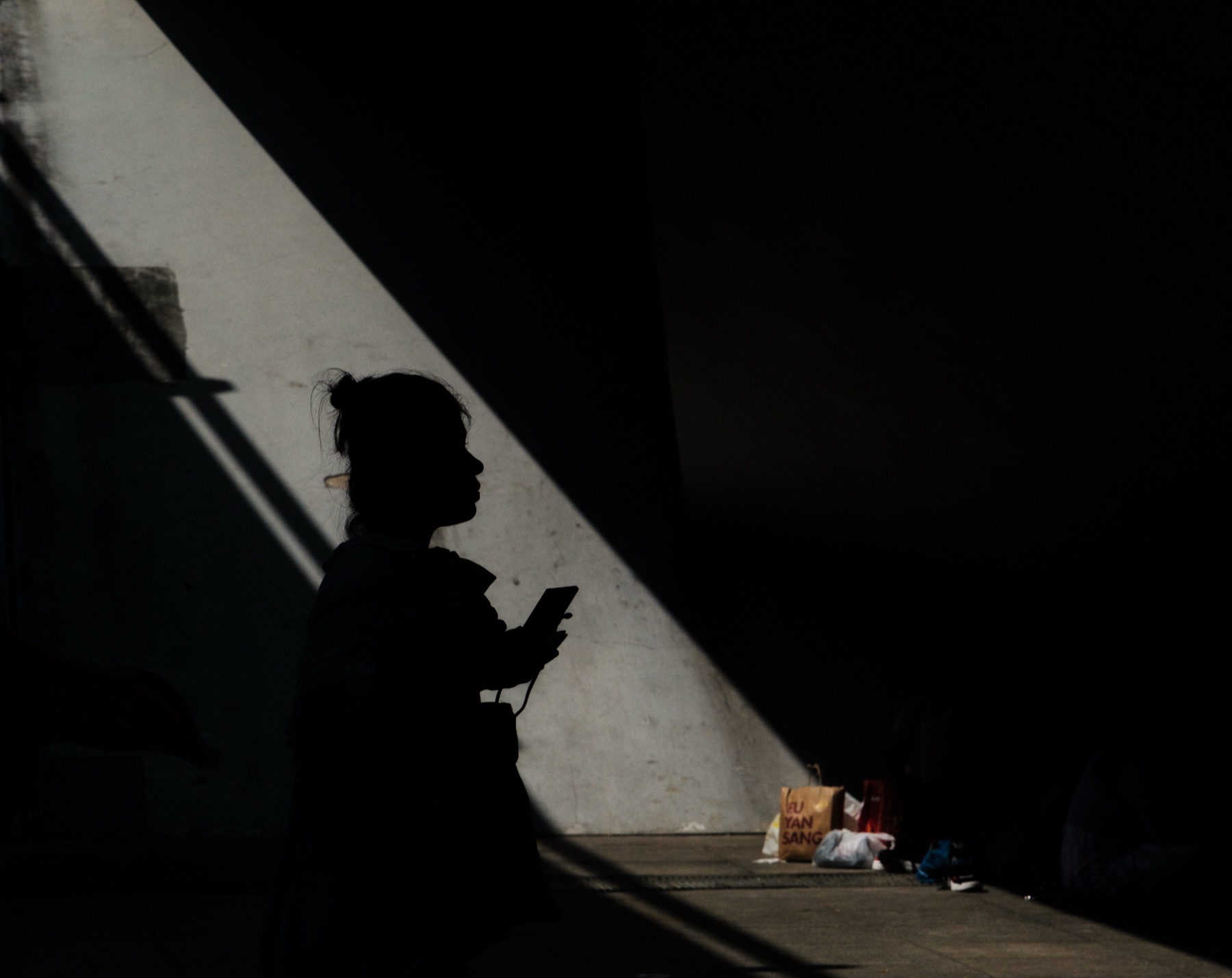 A woman's silhouette against a hard diagonal shaft of light