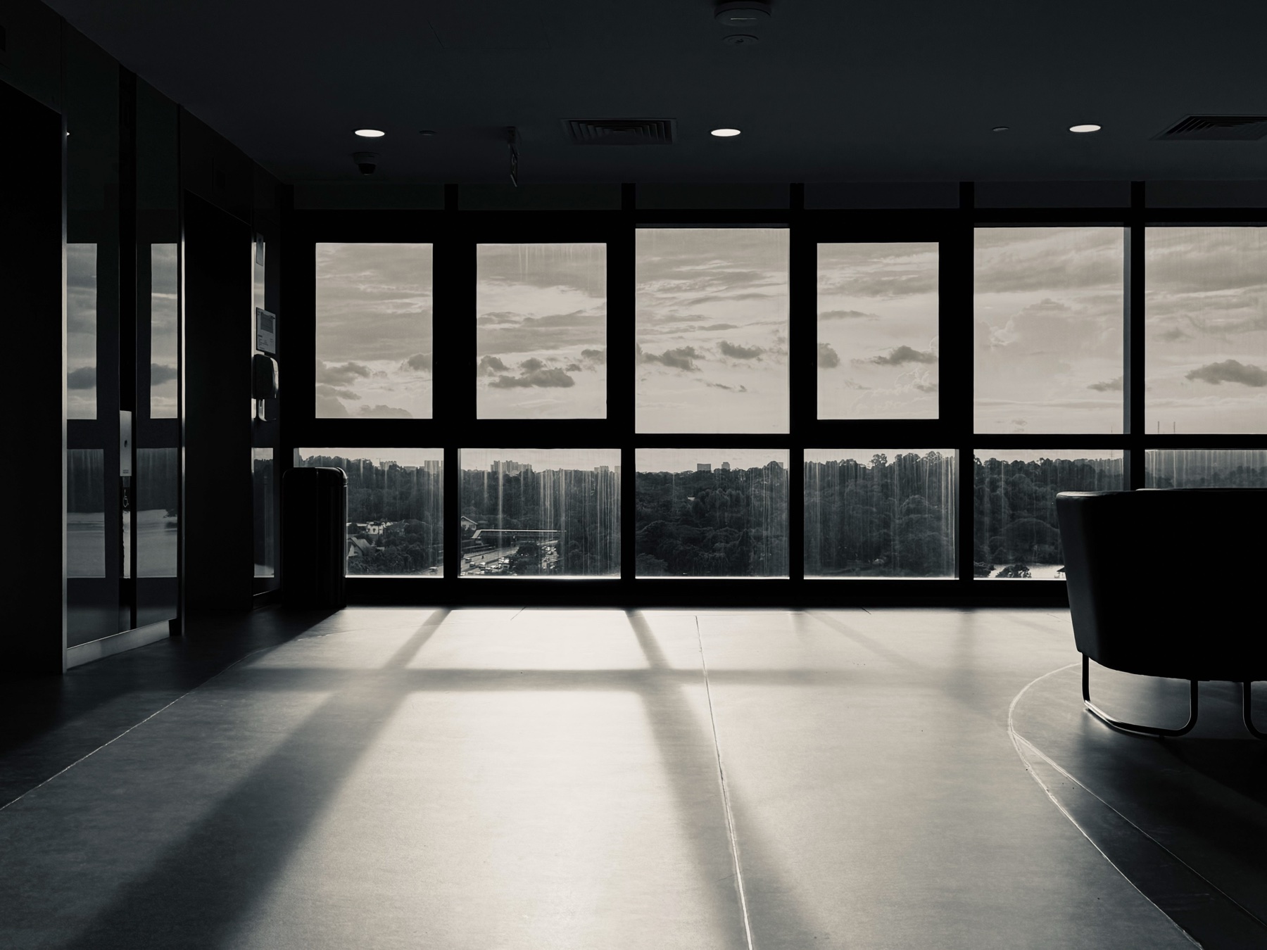 An empty room with light pouring across the floor from a wall of windows